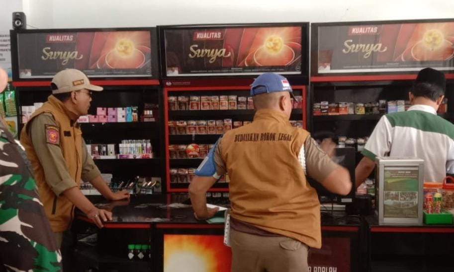 OPERASI: Satpol PP Pamekasan saat merazia toko yang diduga menjual rokok ilegal. (Khoyrul Umam Syarif/ Kabar Madura)