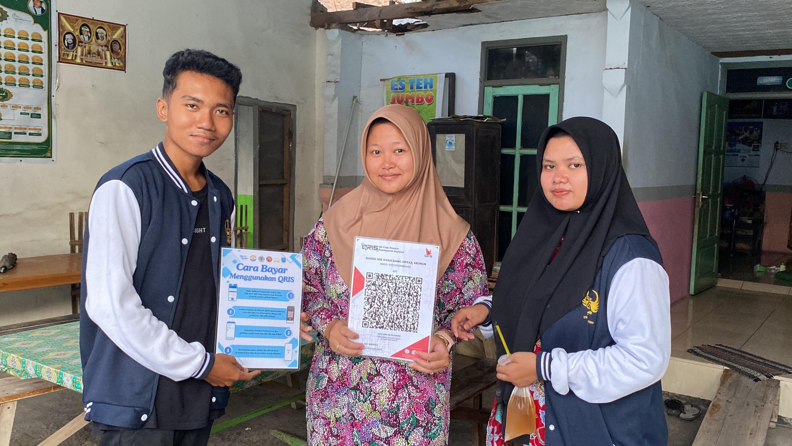 INOVATIF: Mahasiswa KKN Unitomo memperkenalkan sistem pembayaran digital kepada pelaku UMKM di Desa Temenggungan. (Khoyrul Umam Syarif/Kabar Madura)