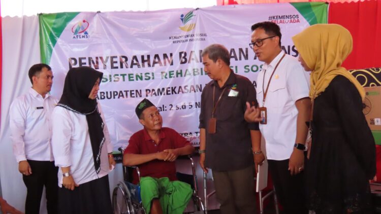 MANUSIAWI: Anggota DPR RI Hj Ansari (kerudung hitam) saat menyerahkan kursi roda kepada warga Madura. (Khoyrul Umam Syarif/Kabar Madura)