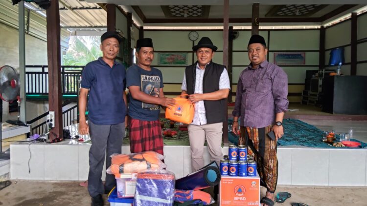 KEMANUSIAAN: Wabup Pamekasan H. Sukriyanto (pakai topi) saat menyerahkan bantuan. (Mulyadi Izhaq/Kabar Madura)