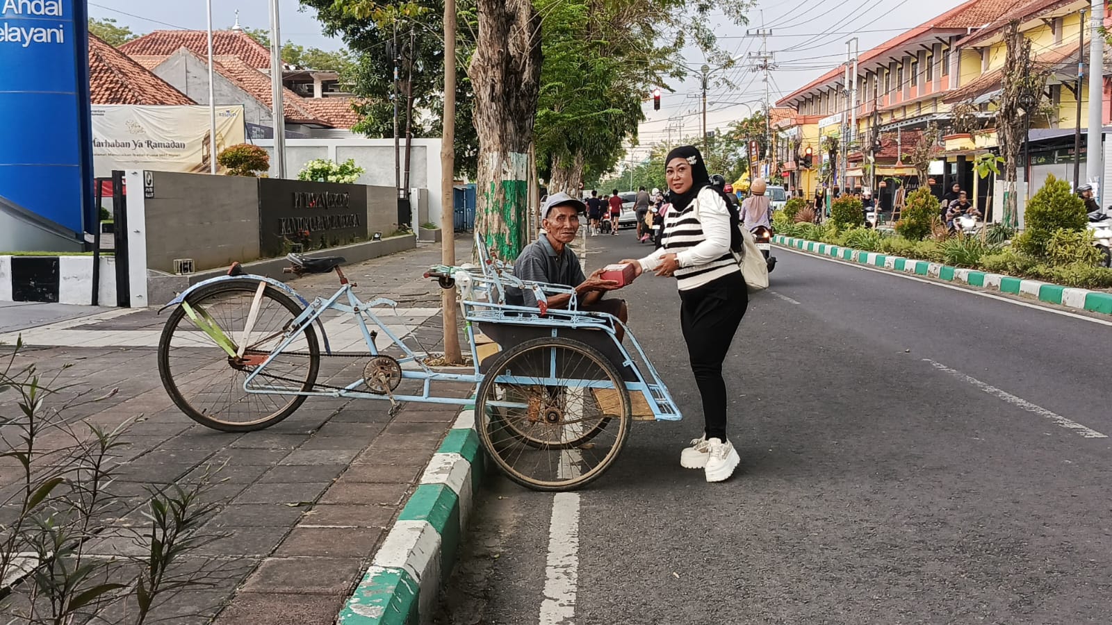 SPIRIT KEMANUSIAAN: Pengurus JMP berbagi ratusan snack box kepada para tukang becak, tukang parkir, dan pengemudi Ojol. (Ist/Kabar Madura)